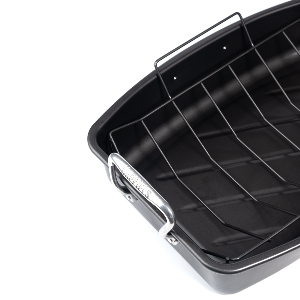 Black roasting pan with wire rack on a white background