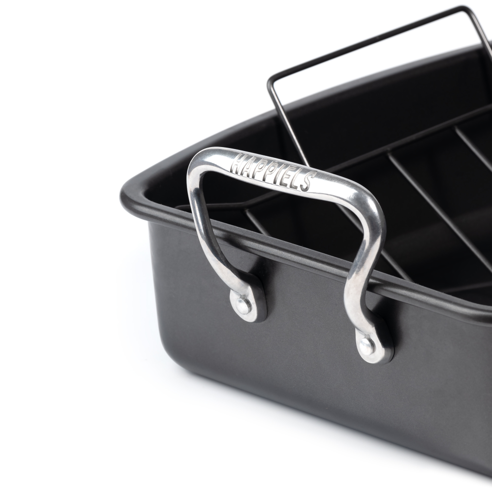 Black roasting pan with silver handles on a white background